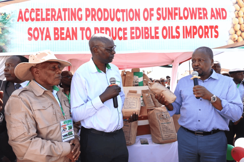 KALRO Chairman Dr. Thuo Mathenge James Njoroge a scientist based at the KALRO Food Crops Research Center in Njoro and Cabinet Secretary Mutahi Kagwe with sunflower and soybean seeds developed by KAL